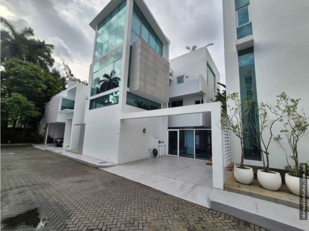 Modern white facade with glass walls lush garden Altos del Golf Panama City