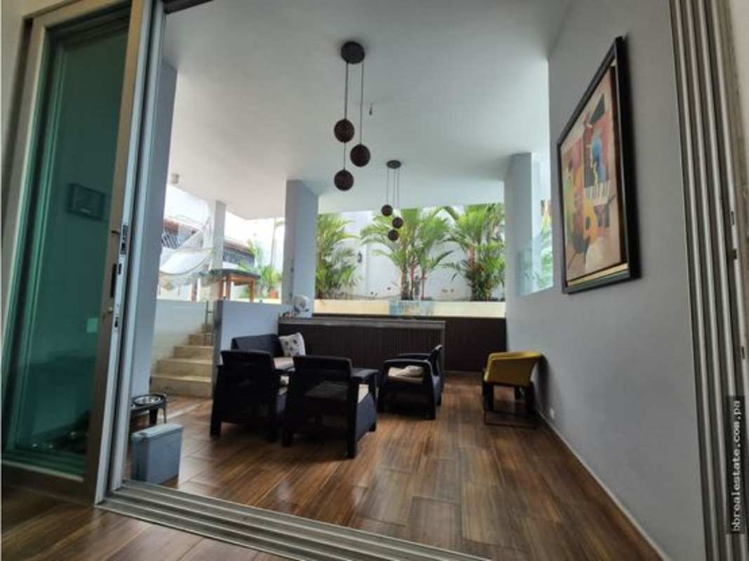 Living area with wooden floor big windows tropical garden minimal house Panama City