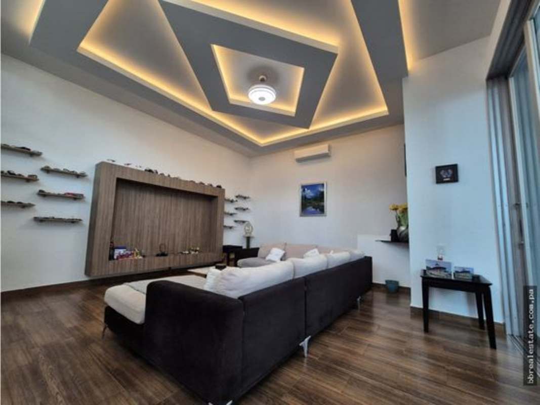 Living room with wood floor LED ceiling feature wall in Altos del Golf mansion Panama