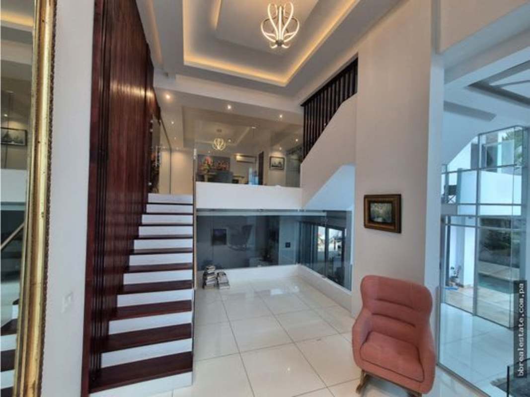 Double height foyer staircase glass railing minimalist style Altos del Golf Panama