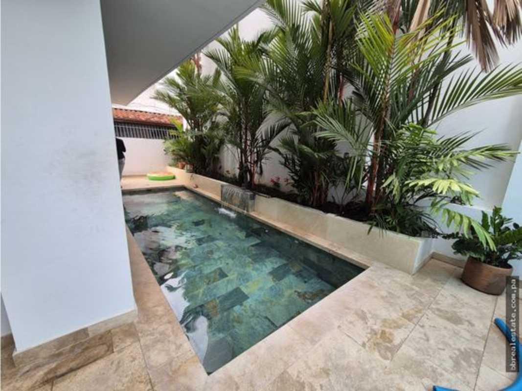 Courtyard with turquoise plunge pool palm trees modern minimal house Altos del Golf Panama