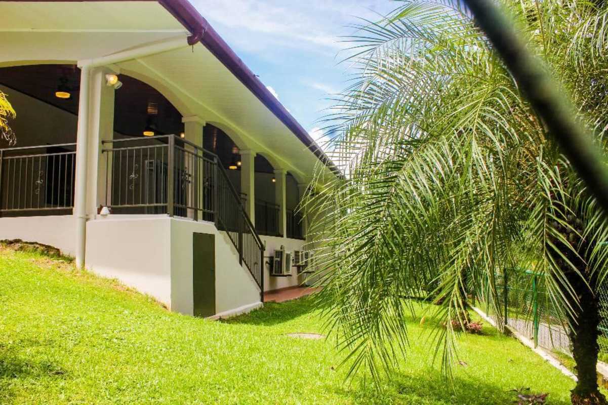 Front covered porch with arches overlooking lush lawn and tropical garden Clayton Panama rental home