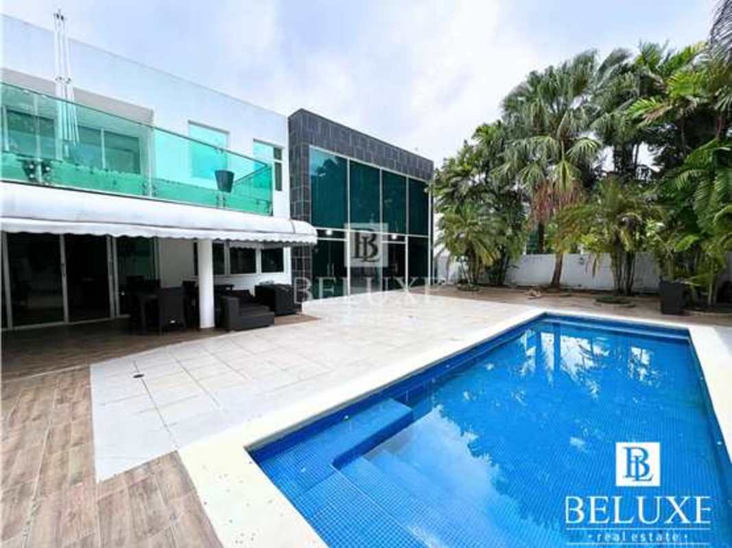 Modern foyer with glass stairway and double-height ceilings in luxury home Costa Esmeralda Panama
