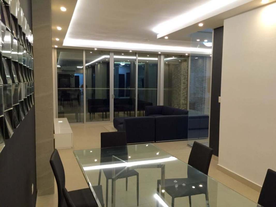 Spacious modern dining and living area with glass doors to balcony at PH Rivage Panama