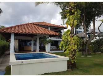 Two-story Mediterranean-style villa with terracotta roof lush gardens and private pool Rio Hato beach Panama