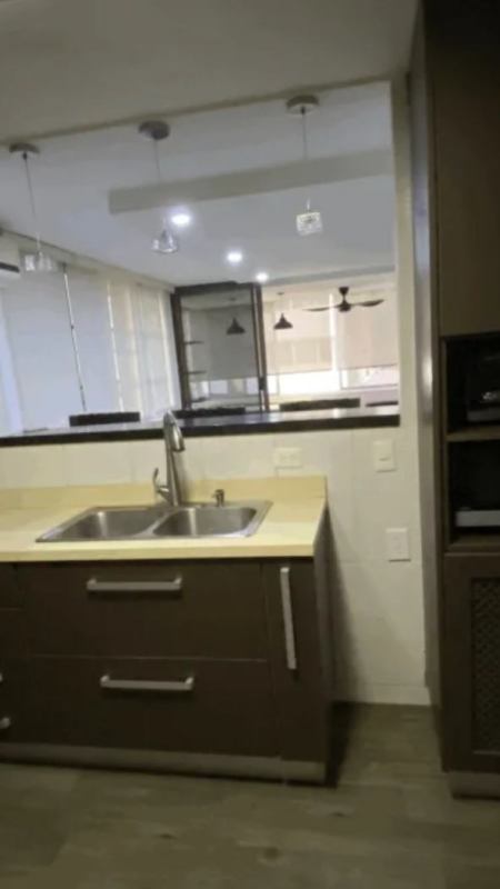 Exterior view of PH Girasol condominium with balconies and landscaped palm trees in Marbella Panama