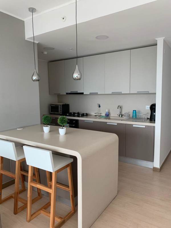 Fully equipped kitchen with granite counters and modern cabinets in Coco del Mar apartment