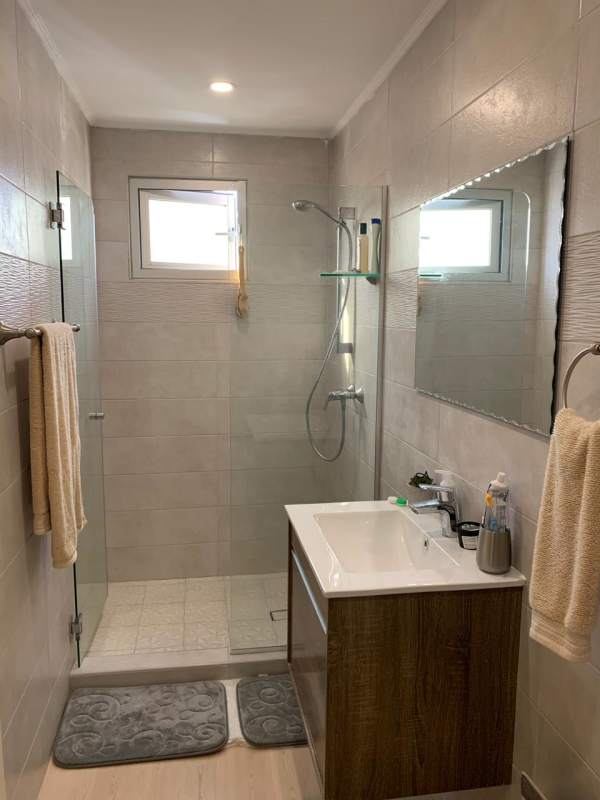 Renovated bathroom with glass enclosed shower modern fixtures Coco del Mar Panama