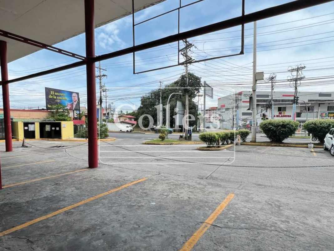 Covered parking area and storefronts facing busy avenue at PH Mystic Park Juan Diaz Panama City