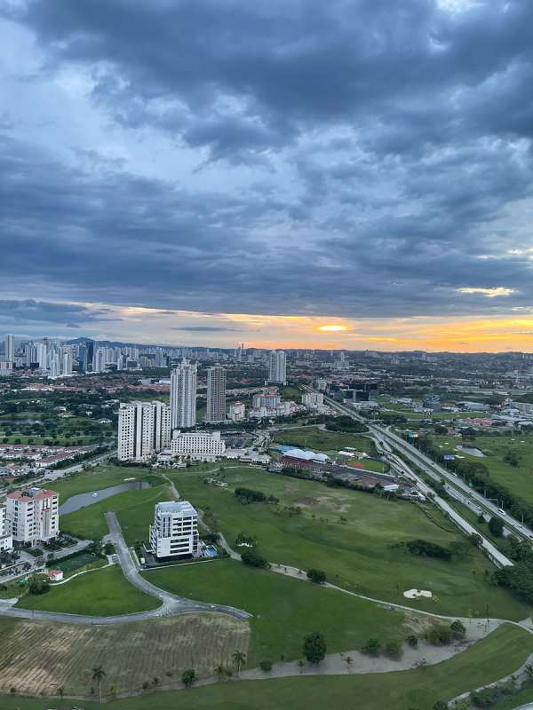Aerial view of luxury towers, green golf fairways, sunset skyline within Santa Maria Panama