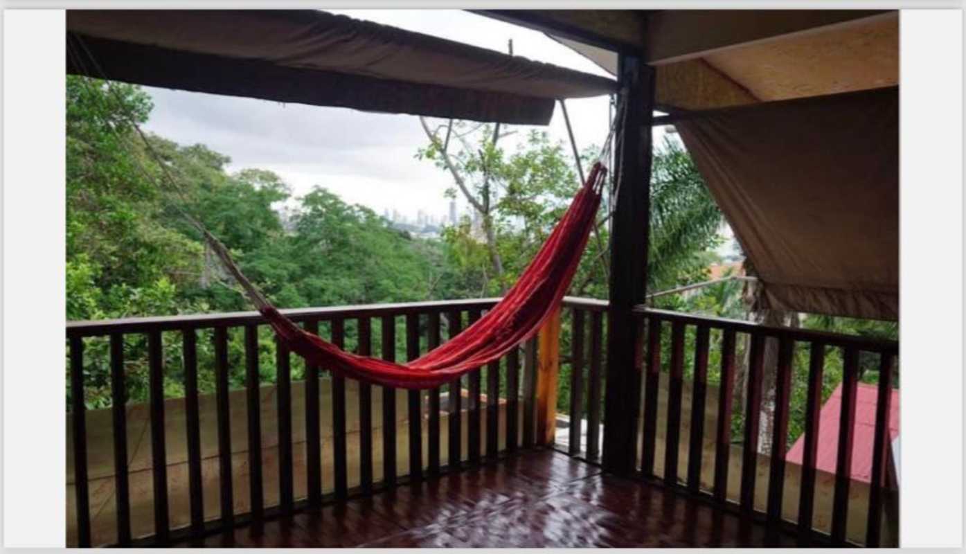 Large multilevel green home with balconies surrounded by lush gardens in Ancon Hill Panama