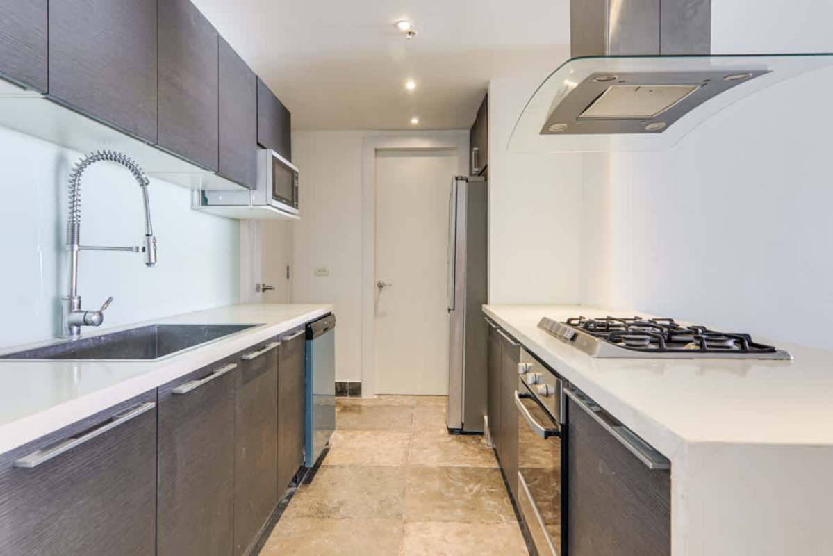 Contemporary kitchen with granite counters and appliances in YOO Panama apartment