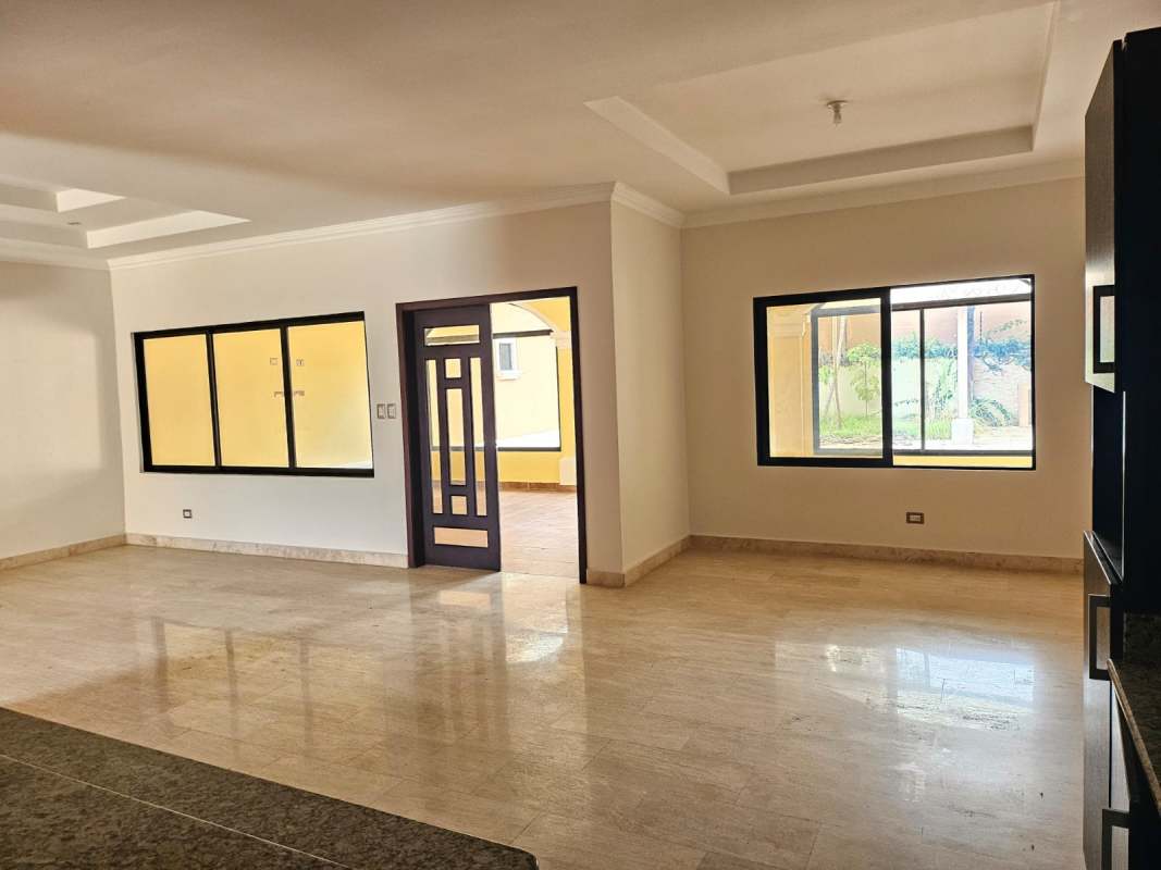 Open living-dining space with natural light marble flooring and garden view in Costa Sur Panama City