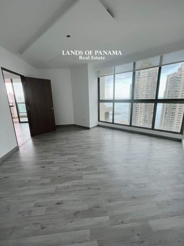 Dining space with floor to ceiling windows overlooking city skyline and ocean in PH Ocean Park Panama