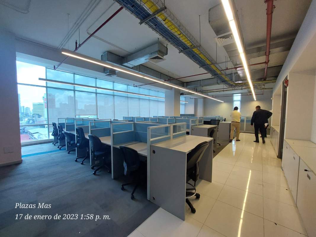 Large open-plan corporate office with cubicles and city views in PH Tula Panama