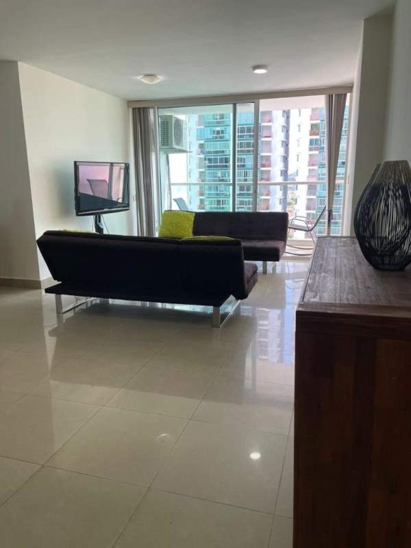 Living room with black sofas, balcony access overlooking Costa del Este Panama