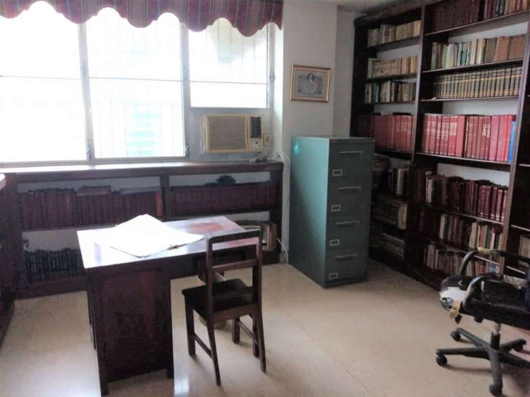 Living room with wooden shelving blue sofa sheer curtains PH Gina Obarrio