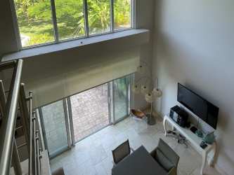 Bedroom with double-height ceiling and private balcony in beach condo Buenaventura Panama