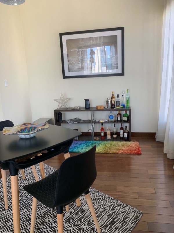 Contemporary dining space with large window and skyline view inside Denovo apartment Panama