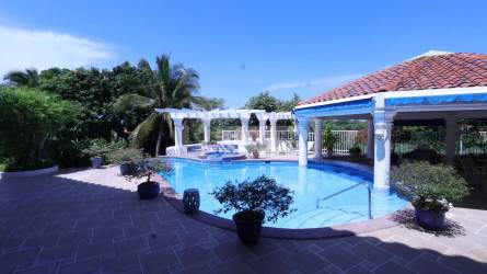 Bright sitting area with wicker furniture, large window, tropical decor at Coronado Golf Beach Home