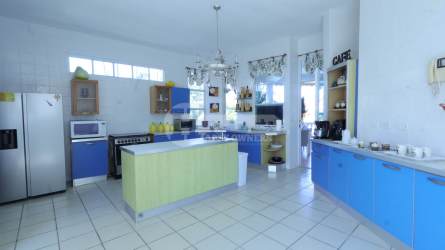 Modern kitchen with island, stainless appliances, blue cabinets in Coronado Beach villa Panama