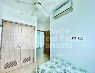 Bright bedroom with built-in closet, AC, ceiling fan, balcony access and ocean views in Santa Clara Residences