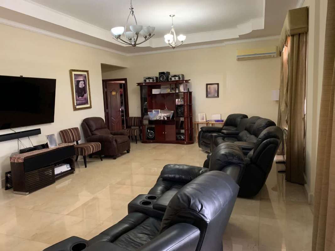 Spacious living room with black leather sofas and entertainment center in Parque Lefevre Panama City