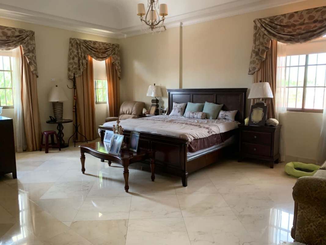 Spacious master bedroom with king bed, traditional decor and garden views in luxury Chanis house Panama
