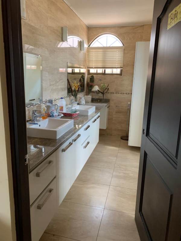 Contemporary bathroom with granite countertop, double sinks and arched window Chanis Panama City