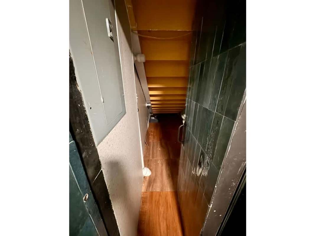 Under stair storage with electrical panel, tiled wall and brown floor San Francisco Panama