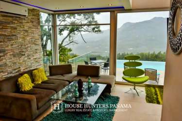 Contemporary living room with floor-to-ceiling windows mountain views Altos del Maria