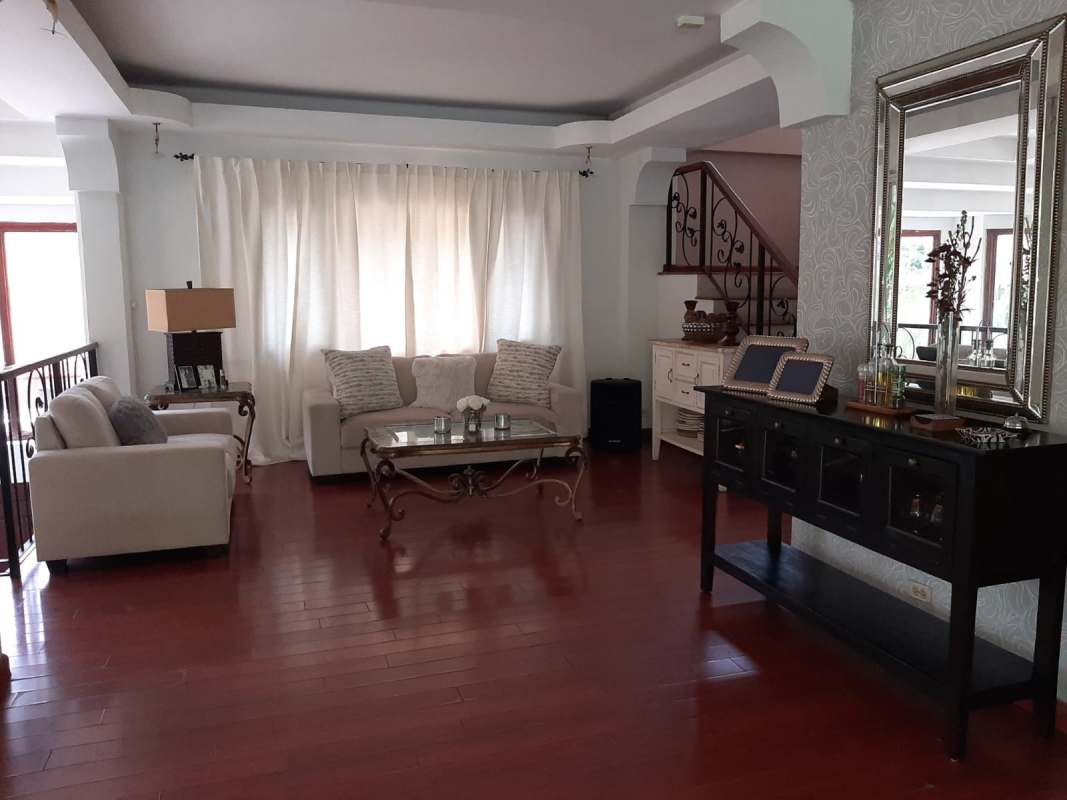 Dining area with glass table, large windows, wood floors in Albrook house Panama