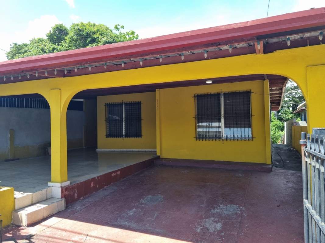 Covered parking with metal roof and tiled floor in front of house Panama City