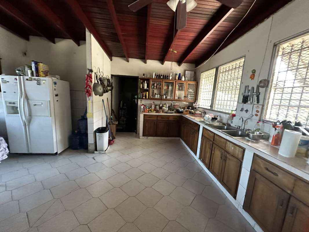 Rustic traditional kitchen with exposed beams and wooden cabinets in Las Cumbres Panama