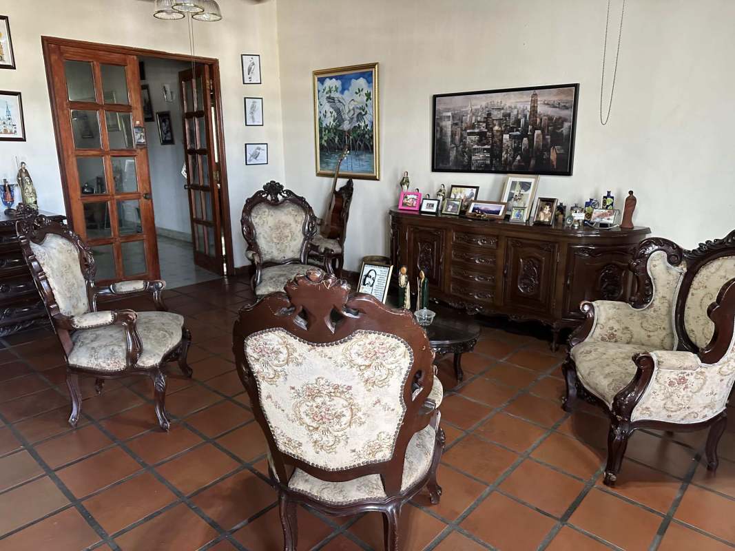 Living room with ceramic tile floor and ornate wooden furniture in Las Cumbres Panama