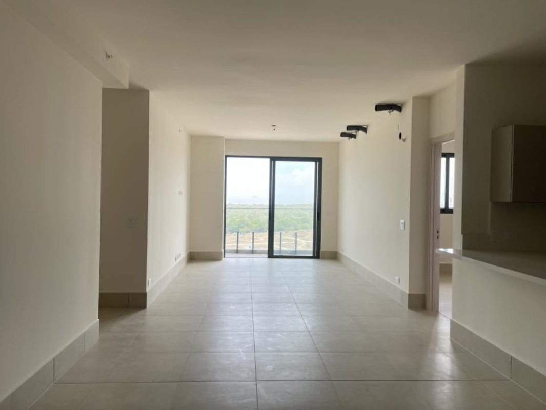 Spacious living and dining area with sliding glass doors to balcony overlooking golf course at Ocean House Panama