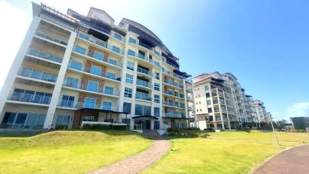Modern beachfront condominium towers with balconies and green landscaping in Playa Escondida Colon Panama