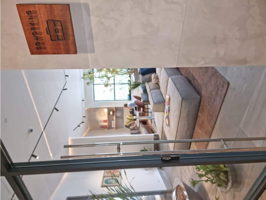 Modern coworking lounge with sofas, glass partitions and greenery in Panama apartment