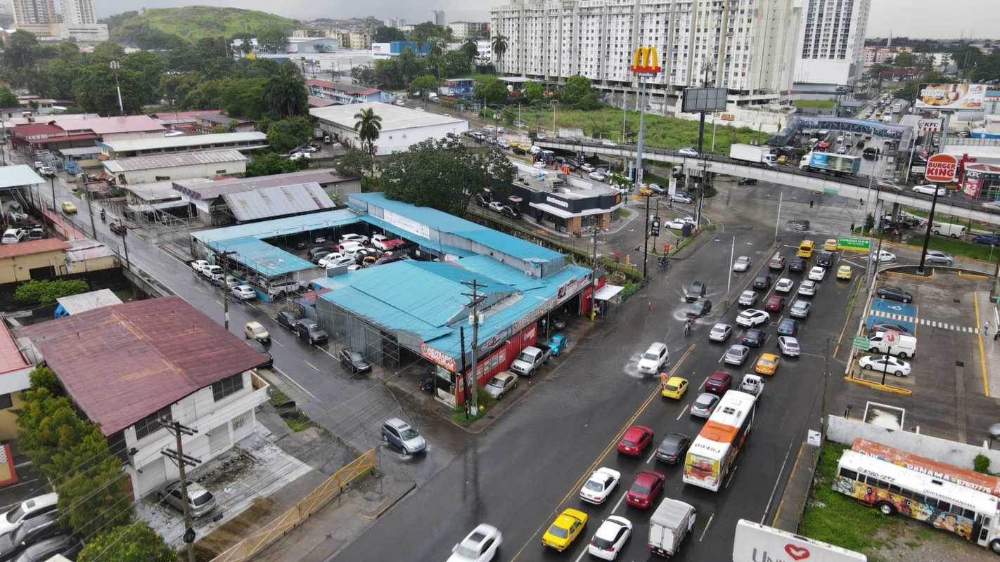 City aerial of busy corner lot surrounded by fast food, auto dealerships, and urban streets in Rio Abajo Panama City.