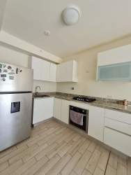 Bright kitchen with oven, stove, granite counters in Playa Caracol apartment Panama