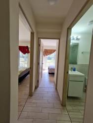 Bright tiled hallway leading to spacious bedrooms in Playa Caracol Beach Condo Panama