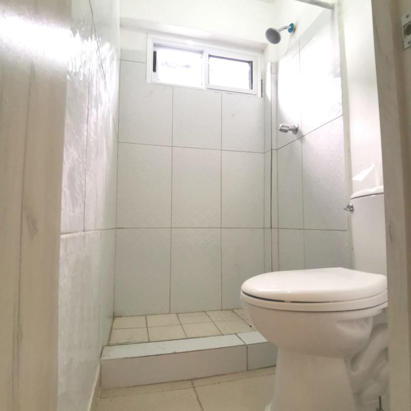 Minimalist bathroom with walk-in shower pedestal sink tile finishes La Felicidad La Locería Panama