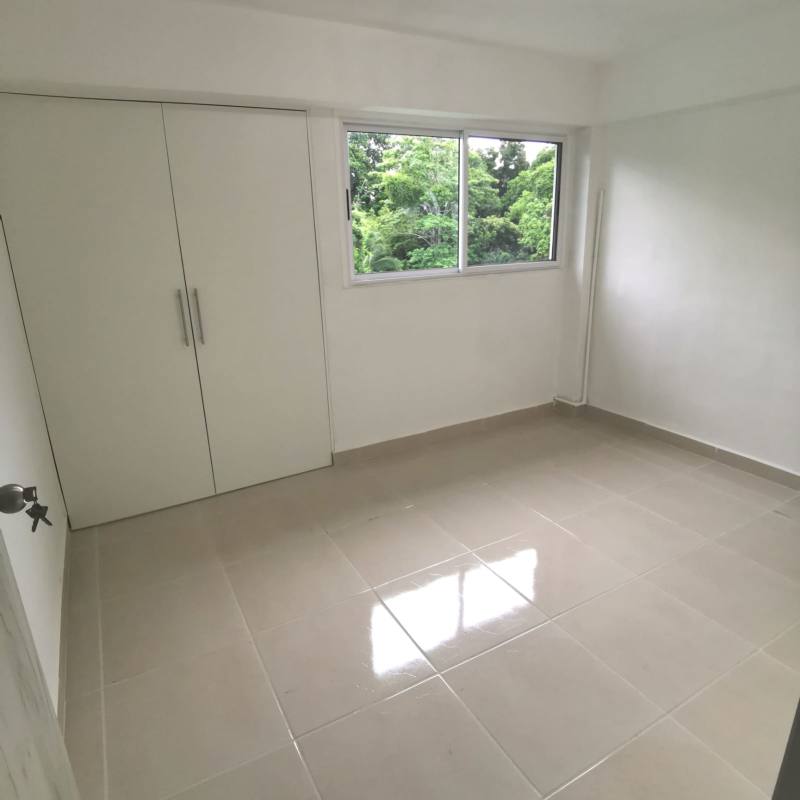 Bedroom with large window and built-in closet in La Felicidad apartment La Locería Panama