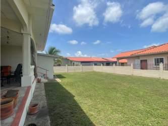 Expansive fenced yard with grass and covered patio in Paseo del Río