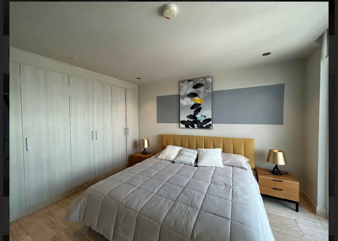 Furnished primary bedroom with large windows city view ensuite bathroom at PH Regent Costa del Este Panama