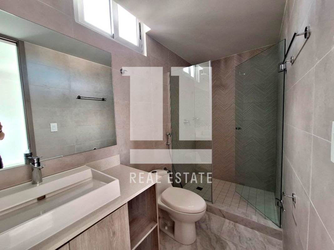 Bathroom featuring glass shower enclosure, large mirror and modern finishes PH Luxor Towers Panama