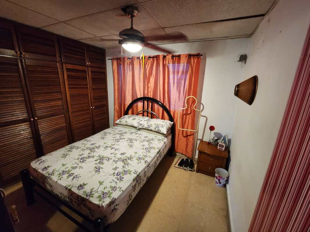 Traditional bedroom with wood closet, ceiling fan, window curtains in house at Brisas de Santa María Panama