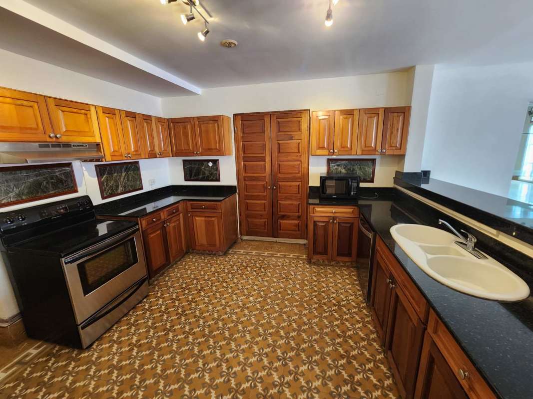 Colonial style kitchen with granite countertops, wood cabinetry, modern appliances in Casco Viejo Panama