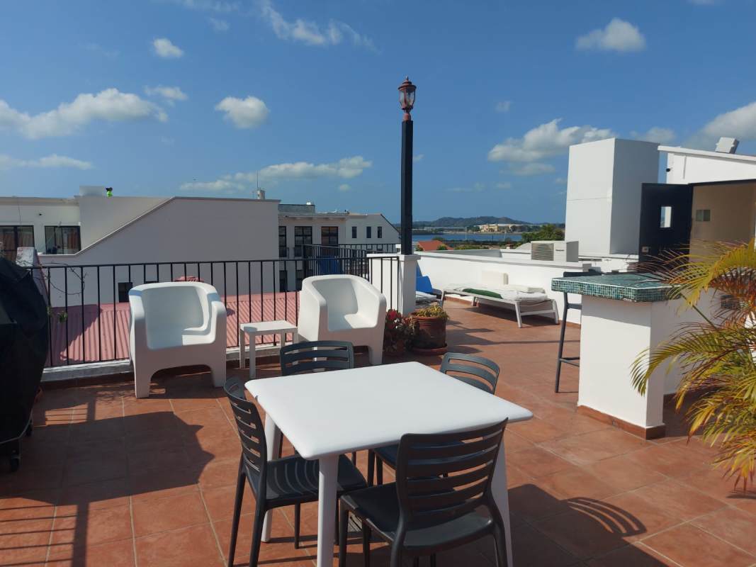 Bright bathroom with walk-in shower, pedestal sink, tiled walls and glass block detail Casco Viejo Panama