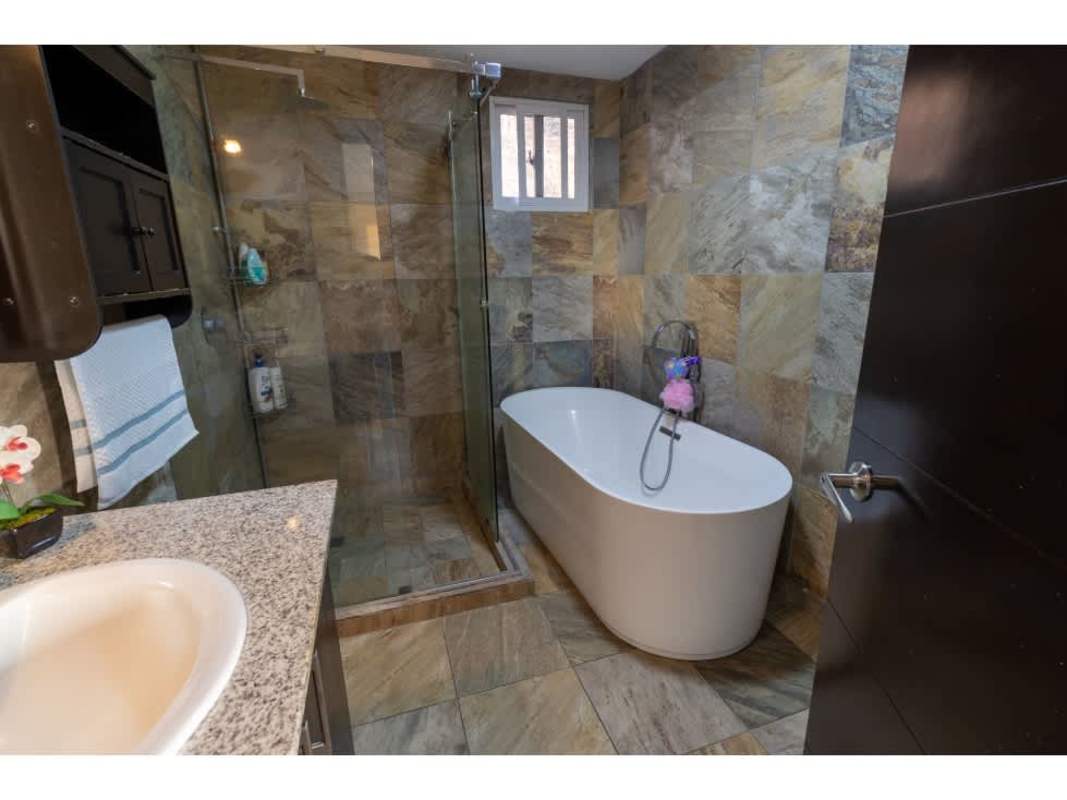 Contemporary bathroom with bathtub and elegant stone tile design in Limajos house for sale in Panama